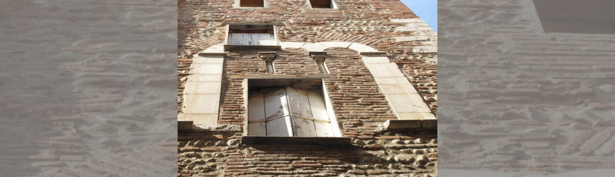 Façade en briques qui a conservé à l'étage des vestiges d'une baie  à 3 arcades et 2 colonnettes